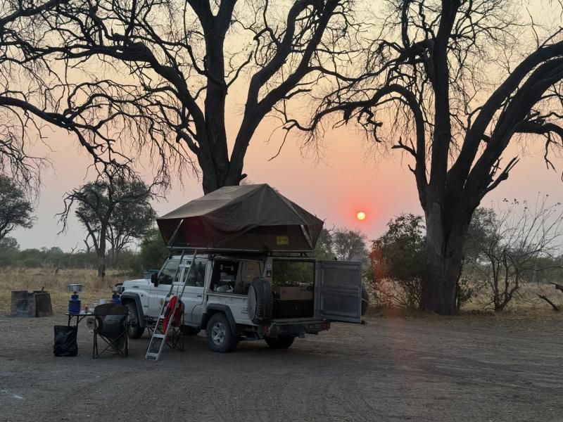 Camp mit Dachzelt bei Sonnenuntergang