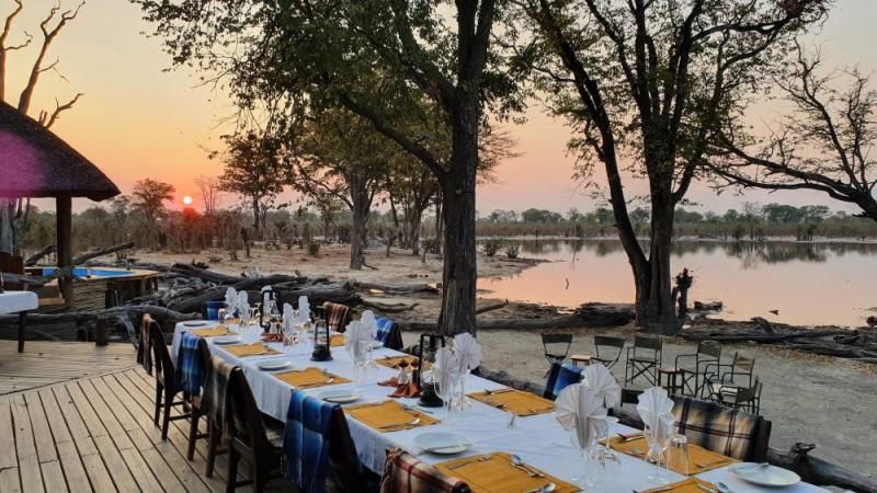 Gedeckter Tisch bei Sonnenuntergang am Wasserloch