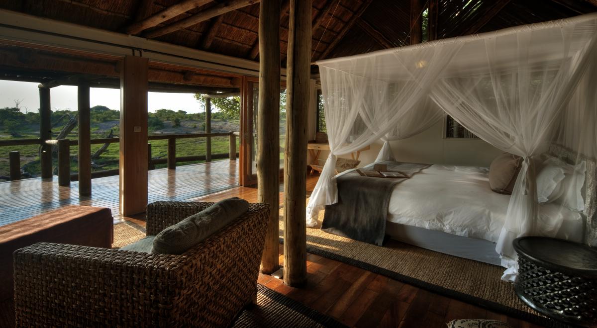 Honeymoon-Suite in einem Partnerhotel von afrika tours individuell mit Himmelbett und Balkonaussicht auf ein Wasserloch mit Wildlife