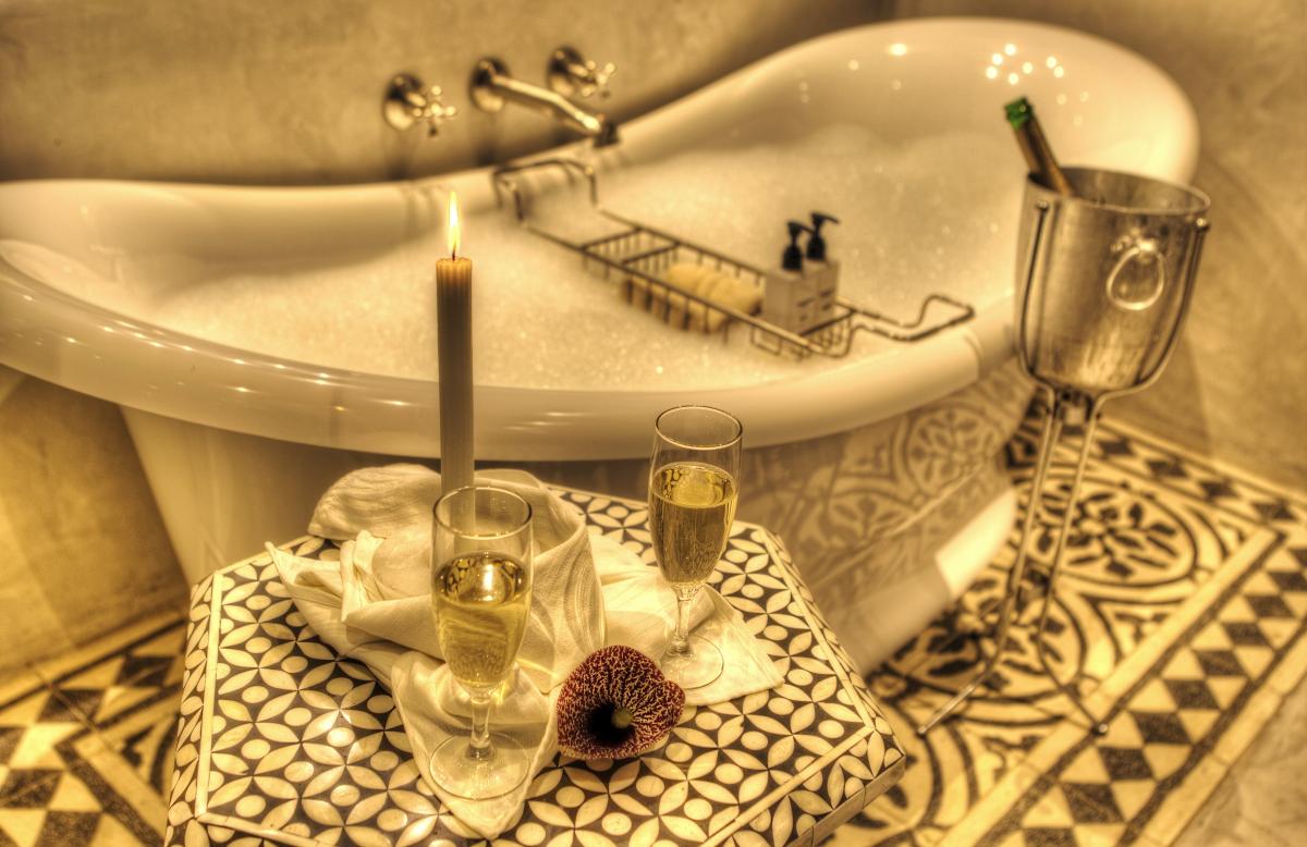 antike Badewanne mit Löwenfüssen, dazu Champagner-Flasche, Glässer und schönes Schaumbad zum Relaxen